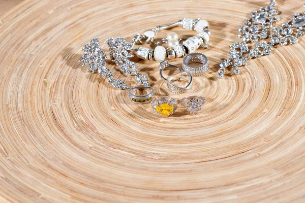 Luxe sieraden set. Wit goud of zilveren ringen, oorbellen met kristallen en hanger aan houten achtergrond. Selectieve aandacht. — Stockfoto