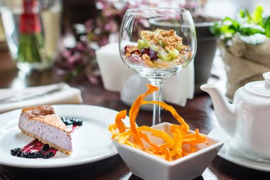 Yaban mersini granola kafede peynirli kek ve meyve salatası.