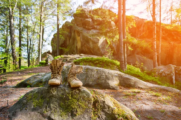 Well-worn hiking boots, unlaced and muddy on the forest floor. Tourism concept. — Stock Photo, Image