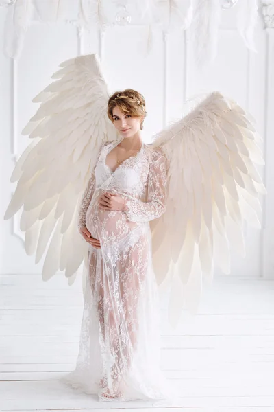 Beautiful young pregnant girl with big angel wings — Stock Photo, Image