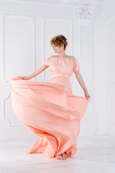 Vrouw dansend in roze avondjurk vliegend op de wind. Wuivende stof, fashion shot. — Stockfoto