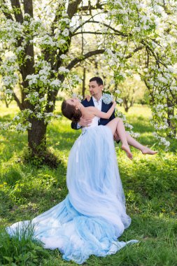 Young wedding couple embracing in blooming spring garden. Love and romantic theme.