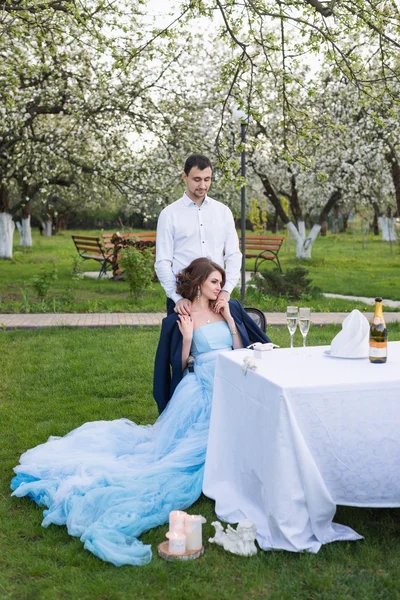 Jong koppel omarmen tijdens de bloei in het voorjaar tuin. Liefde en romantische thema. — Stockfoto