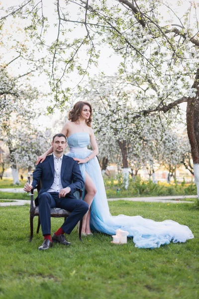 Pareja joven abrazándose en floreciente jardín de primavera. Amor y tema romántico . — Foto de Stock