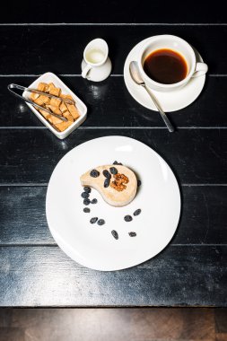 Fincan kahve ve koyu ahşap masa arka plan üzerinde lezzetli pasta.