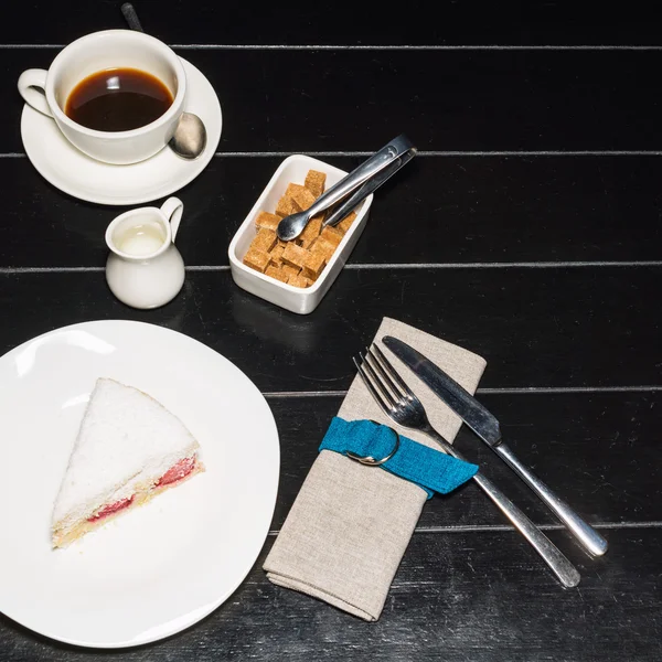 Copa de café y delicioso pastel sobre fondo de mesa de madera oscura . —  Fotos de Stock