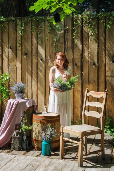 Vacker kvinna ha kul i sommarträdgården. Utomhus vardagsrum med lavendel blommor för fest, tebjudning. — Stockfoto