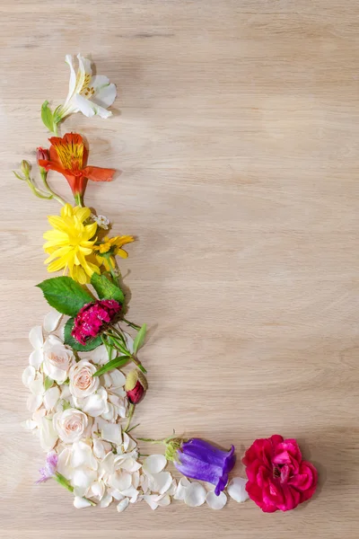 Egy szög fémkeret különböző virágok, a fából készült háttér. — Stock Fotó