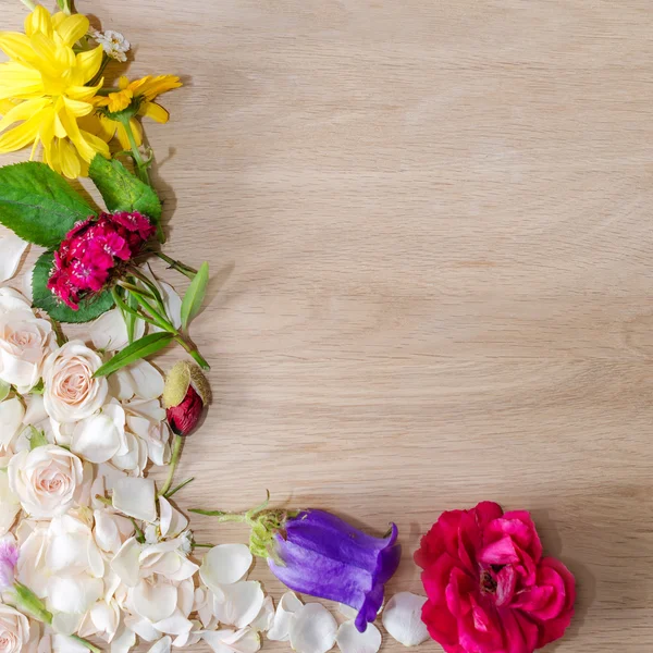 Egy szög fémkeret különböző virágok, a fából készült háttér. — Stock Fotó