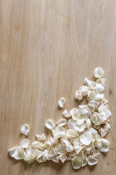 Белые лепестки роз на деревянном фоне с пространством для текста . — стоковое фото