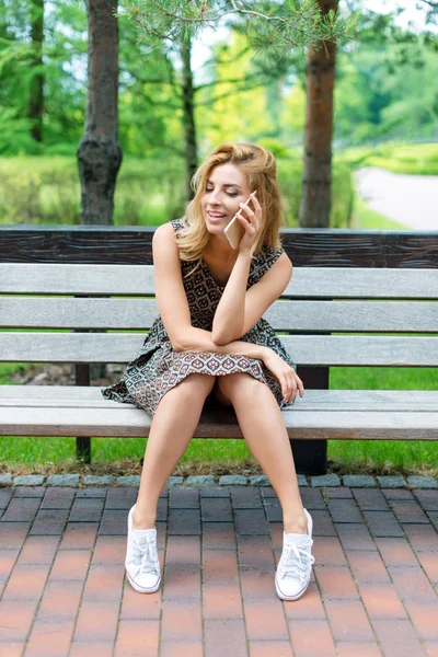 Smiling beautiful woman talking on the phone in the park. — Stock Photo, Image