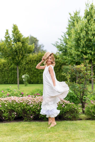 Glada unga blonda kvinnan gå barfota på det gröna gräset — Stockfoto