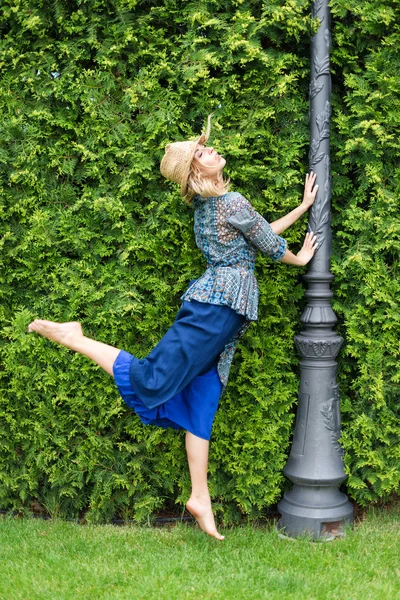 Happy young blonde woman walking barefoot on the green grass — Stock Photo, Image