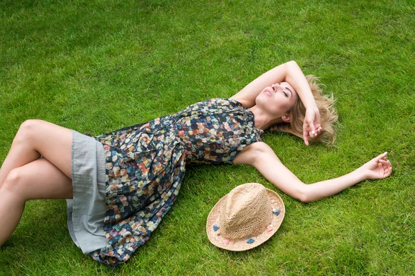 Mujer joven relajándose en un hermoso prado verde . — Foto de Stock