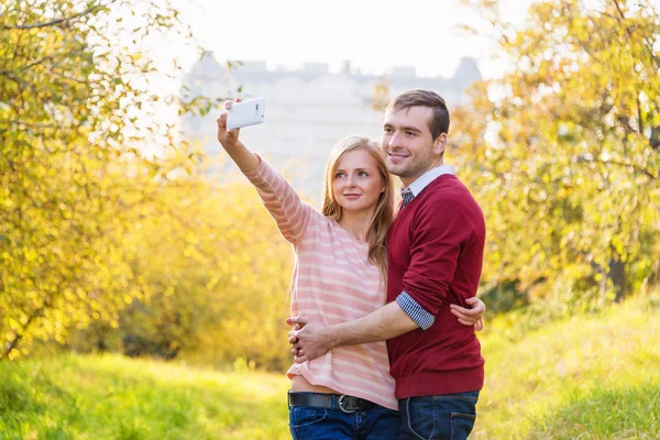 Pasangan muda dalam cinta outdoor mengambil selfie — Stok Foto