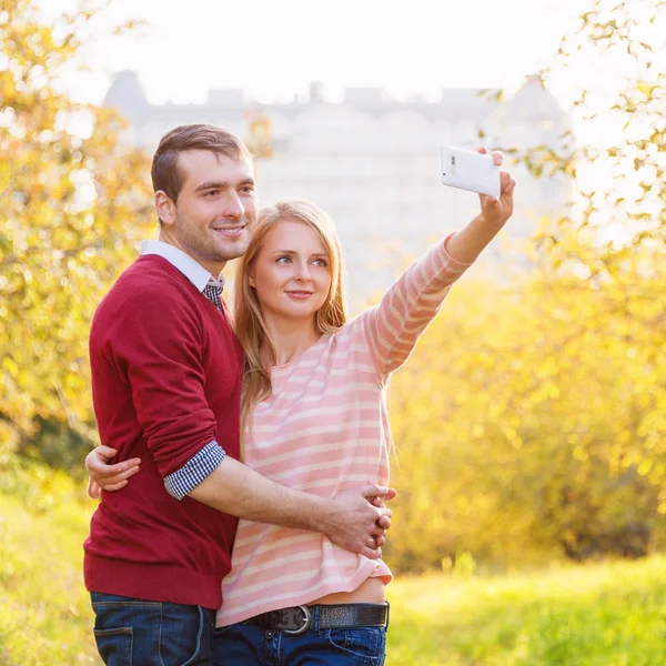 Pasangan muda dalam cinta outdoor mengambil selfie — Stok Foto