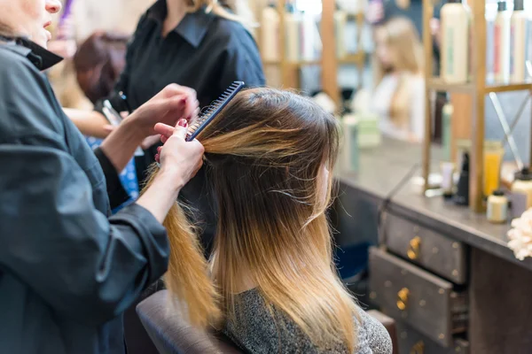 Мастер парикмахерской делает укладку волос — стоковое фото