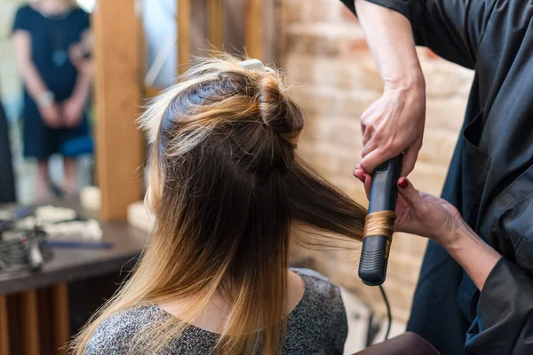 Cabeleireiro profissional usando cachos de cabelo de ferro ondulado — Fotografia de Stock