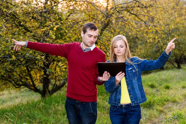 man and woman pointing in opposite directions