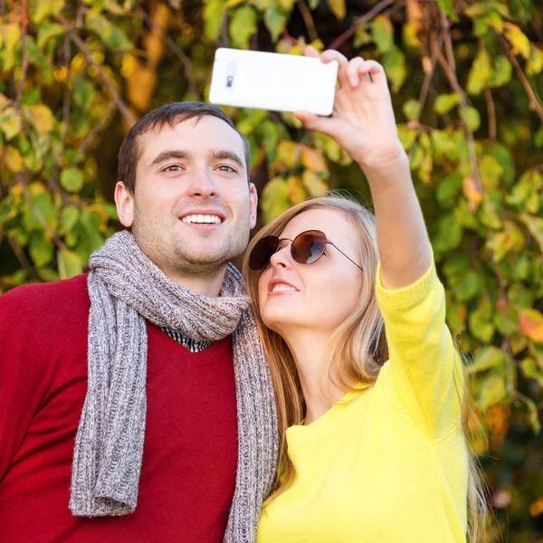 Pasangan muda dalam cinta outdoor mengambil selfie. Cinta, hubungan, musim, persahabatan dan konsep orang . — Stok Foto