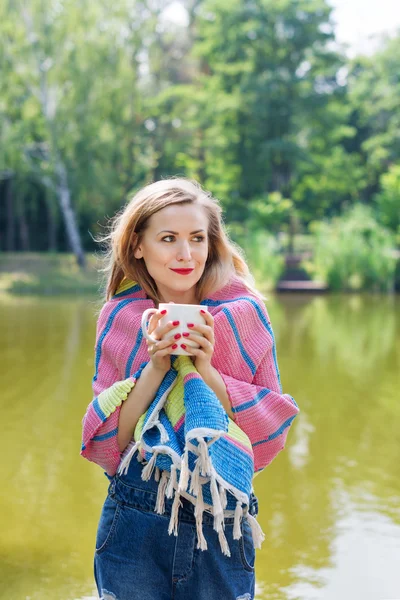Ormanda çay içme bir battaniye sarılı kadın — Stok fotoğraf