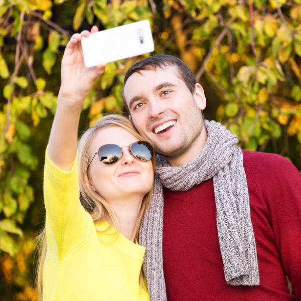 Pasangan muda dalam cinta outdoor mengambil selfie. Cinta, hubungan, musim, persahabatan dan konsep orang . — Stok Foto