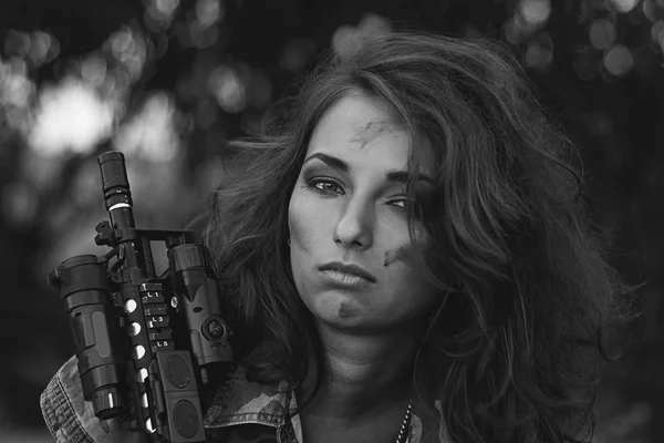 Bewaffnete schöne junge Frau in Tarnung mit Gewehr am Strand. — Stockfoto