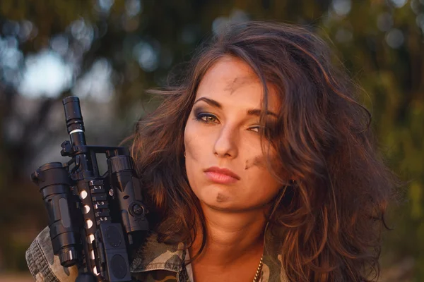 Gewapende mooie jonge vrouw in camouflage met geweer op het strand. Concept van het leger, militair en oorlog. — Stockfoto