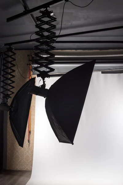 Prázdné fotografické studio s osvětlením a bílým papírem připravené pro fotonatáčení. — Stock fotografie