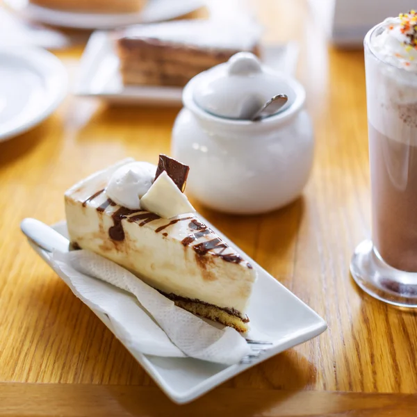 Desayuno o merienda con capuchino cremoso y pastel en mesa de madera . — Foto de Stock