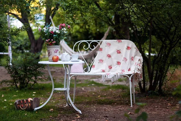Bílý Porcelánový set na čaj nebo kávu na stůl v zahradě nad rozostření pozadí zelené přírody. Letní venkovní strana nastavení. — Stock fotografie