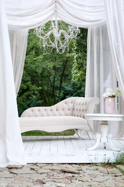 Beautiful garden seating area with modern white sofa, canopy and tea table, gazebo decor idea.