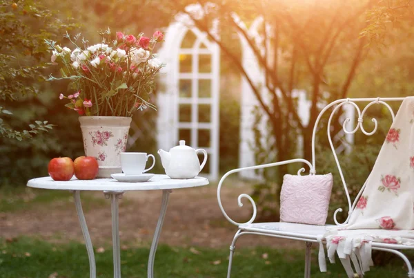 Conjunto de porcelana blanca para té o café en la mesa en el jardín sobre fondo de naturaleza verde borroso . — Foto de Stock