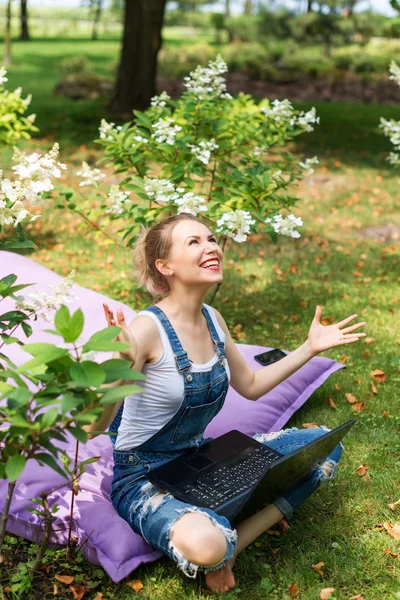 Freelancer working in the garden. Writing, surfing in the internet. Young woman relaxing and having fun in park area. Distance education, freelance concept. — Stock Photo, Image