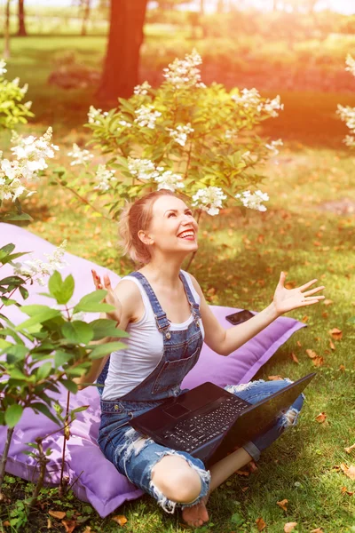 Freelancer working in the garden. Writing, surfing in the internet. Young woman relaxing and having fun in park area. Distance education, freelance concept. — Stock Photo, Image