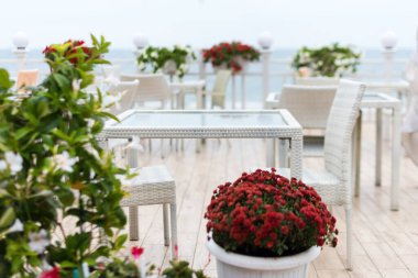 Arka plan bulanık, boş masalar ve denize bakan bir restoranın sandalyeleri. Deniz manzaralı bir kafe. Seaview ile yemek yemek için güzel bir yer. Seçici odak