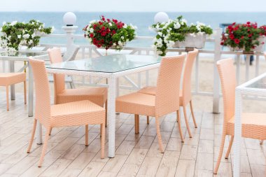 Terasta denize bakan bir restoranın boş masaları ve sandalyeleri. Deniz manzaralı bir kafe. Seaview ile yemek yemek için güzel bir yer. Seçici odak