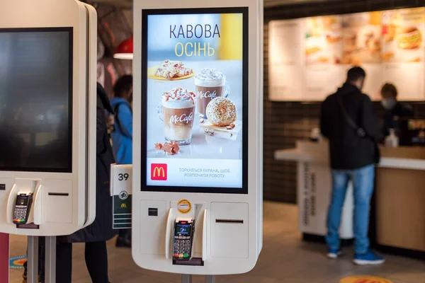 Kyiv, Ukrayna - NOVEMBER 11, 2020: Monitör ekranına dokunarak sipariş vermek için McDonald 's online servis gözlemcileri. McDonald 's restoranında kendi kendine kiosk veya self servis ekranları sipariş etmek