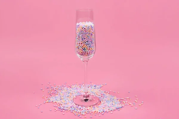 Champagne Glas Gevuld Met Kleurrijke Suikerballen Roze Achtergrond Glas Gevuld — Stockfoto