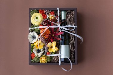 Bir buket çiçek ve bir şişe beyaz şarap eski ahşap kırsal bir kutuda. Romantik hediye, güzel çiçek aranjmanı..