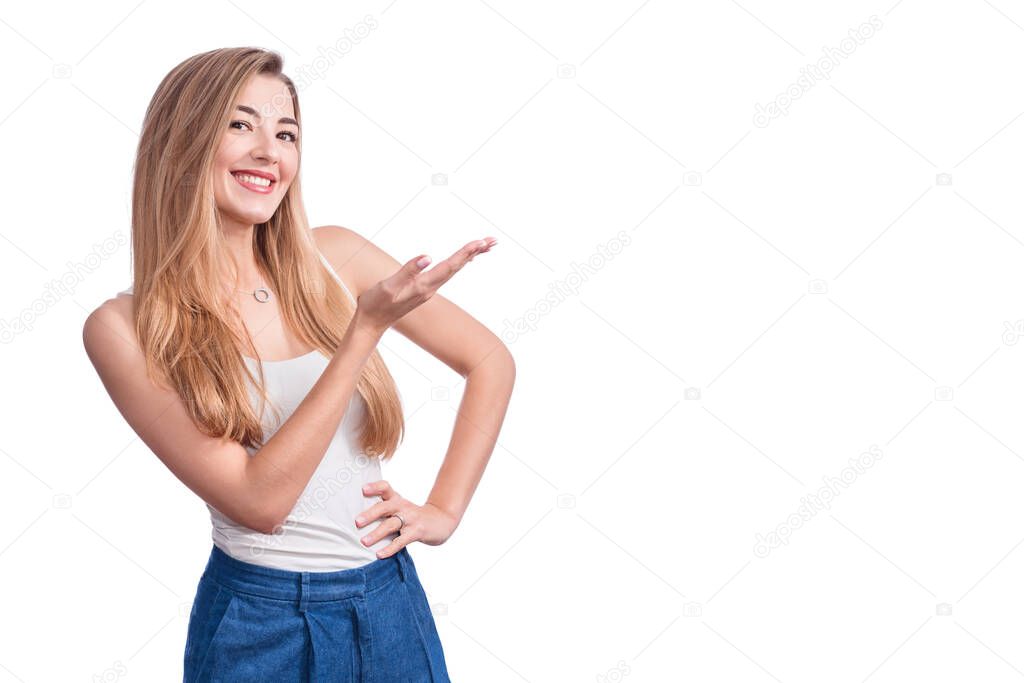 Happy young woman standing isolated over white wall background. Looking camera showing copyspace pointing. Blond young female pointing fingers away. Copy space for your text or advertising content