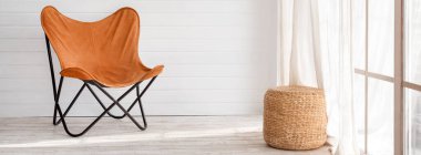 Modern çatı katında modern bir koltuk var. Panoramik pencereli aydınlık oturma odasında güneşli bir gün.