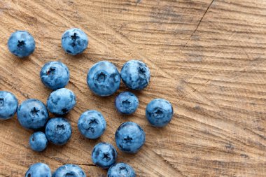 Ahşap masa arkasında yabanmersini. Olgun ve sulu taze toplanmış yaban mersini yakından, üst manzara..