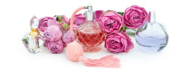 Beyaz arka planda çiçekli parfüm şişeleri. Parfüm, kozmetik, parfüm koleksiyonu..