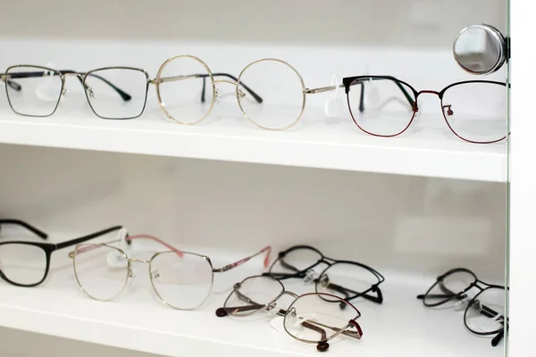 眼镜在眼镜店 不同的眼镜在白色的货架上购物商场 有选择的重点 — 图库照片