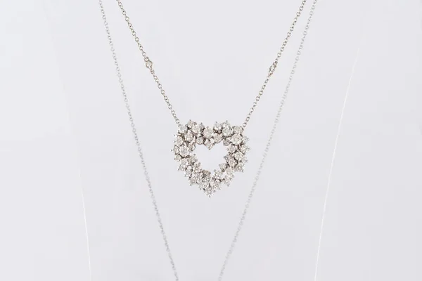 Klassisches herzförmiges Diamant-Halskette auf transparentem Ständer. Liebessymbol. Weißgold mit Diamanten, Modeschmuck. — Stockfoto
