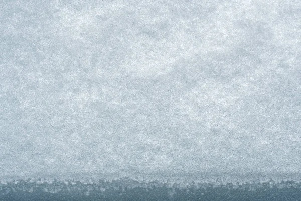 Sneeuwtextuur. Sneeuw voor het raam, besneeuwd winterweer. Ramen bedekt met zware sneeuw. Abstracte achtergrond, textuur voor design — Stockfoto