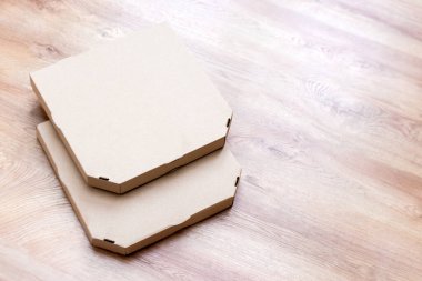 Tahta arka planda pizza kutularını kaldırın. Boş pizza kartonları. Ön manzara yiyecek teslimatı.