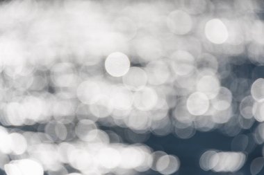 Su perdesi arkaplanı. Güneşte parlayan dalgalarla çözünmüş su yüzeyi.