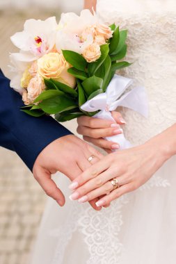 Damat ve gelin elleri yüzüklerle, yakın plan. Yüzüklü kadın ve erkeğin elleri, düğün